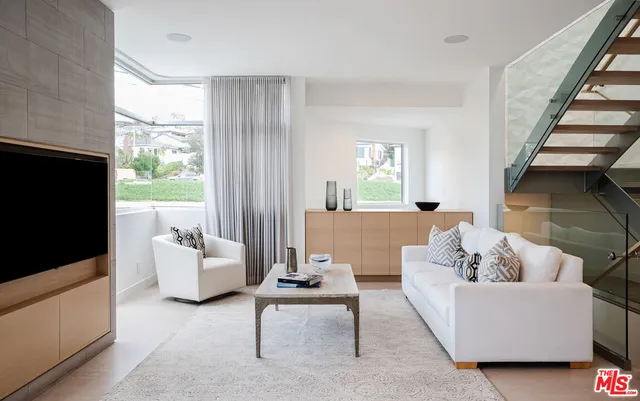 a living room with fireplace furniture and a large window