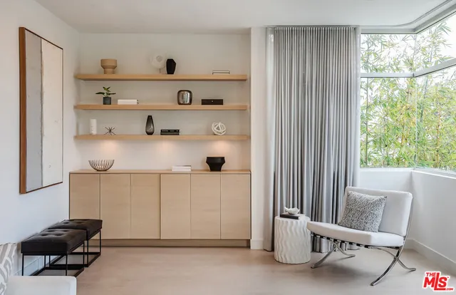 a bedroom with furniture and a large window