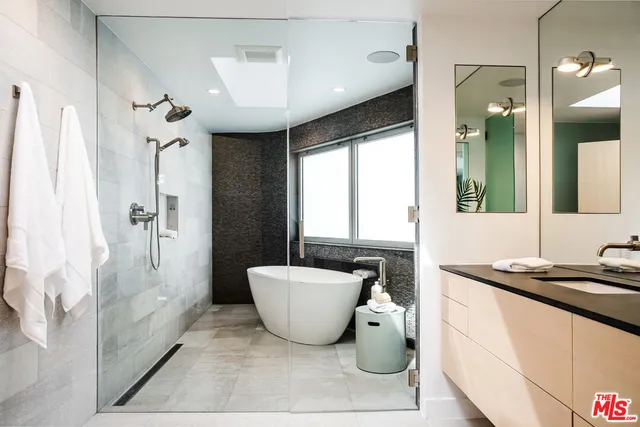 a bathroom with a shower sink and mirror