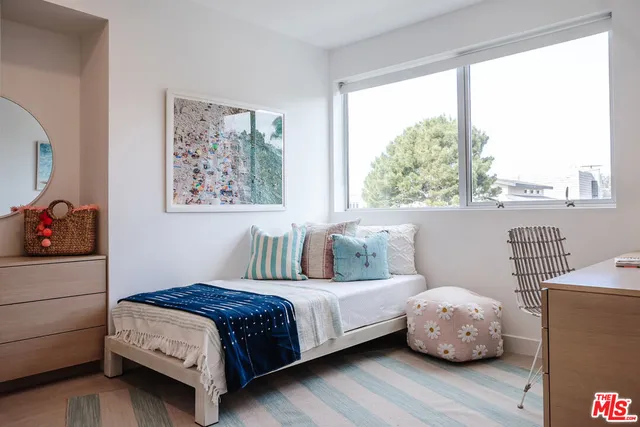 a bedroom with a bed and a painting on the wall