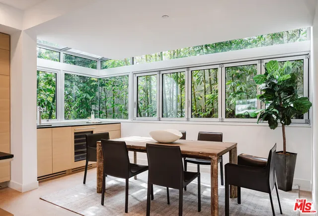 a kitchen with a stove a sink and a dining table with chairs