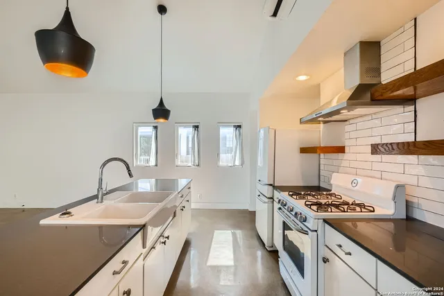 a kitchen with stainless steel appliances granite countertop a sink stove and refrigerator