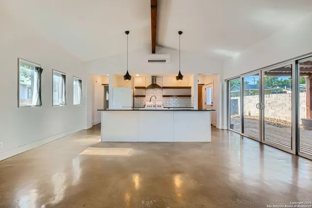 a large kitchen with stainless steel appliances granite countertop a stove a sink and a large window