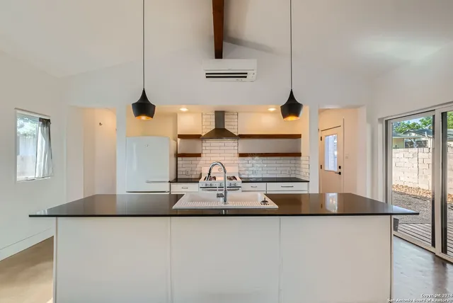 a kitchen with stainless steel appliances granite countertop a sink and a refrigerator