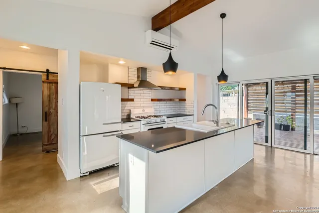 a kitchen with stainless steel appliances granite countertop a sink a refrigerator and a stove
