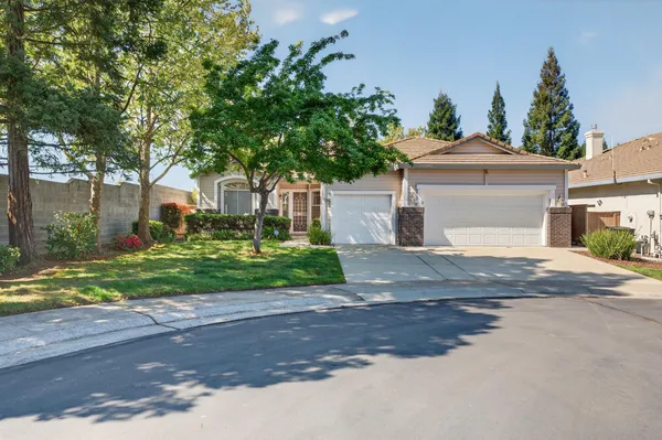 a front view of a house with a yard and trees