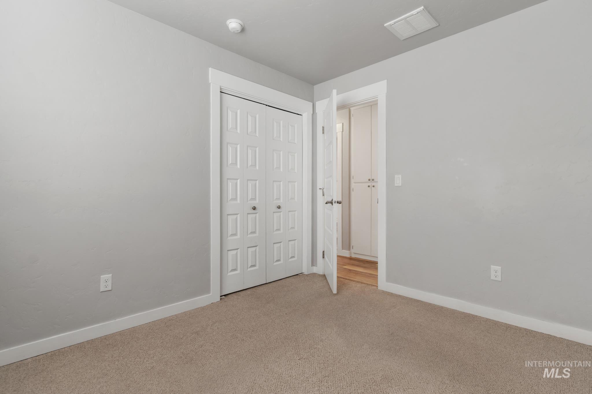 4822 Charme Street Caldwell, ID 83607 - Photo 12 of 22 Unfurnished bedroom with light carpet and a closet