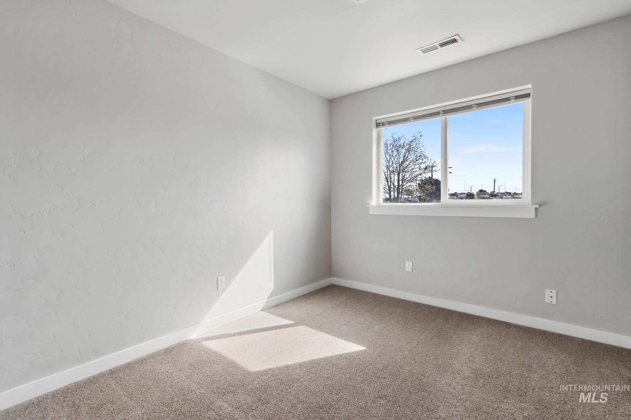 4822 Charme Street Caldwell, ID 83607 - Photo 13 of 22 Empty room featuring light carpet and baseboards