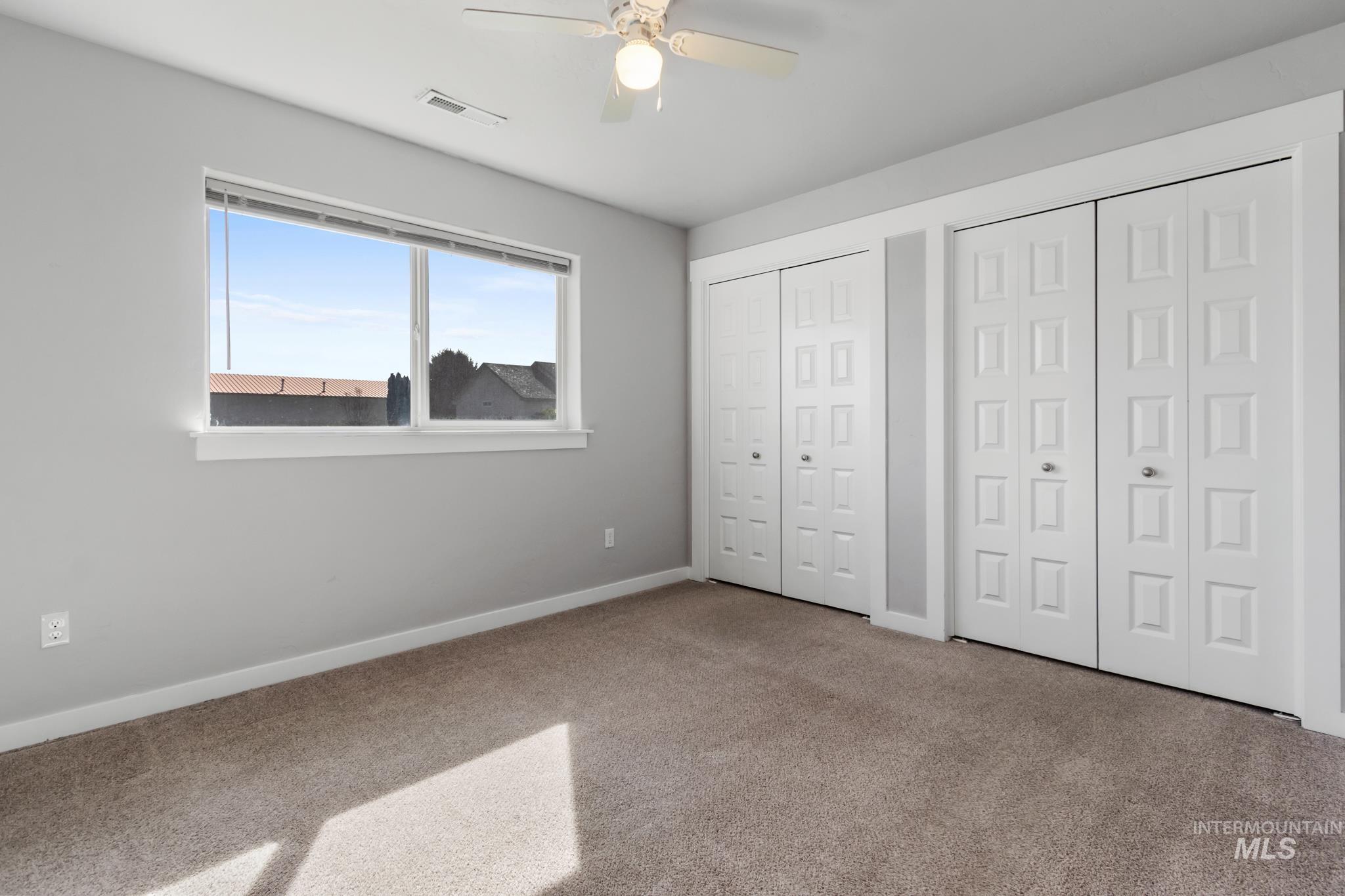 4822 Charme Street Caldwell, ID 83607 - Photo 16 of 22 Unfurnished bedroom with multiple closets, carpet, and a ceiling fan