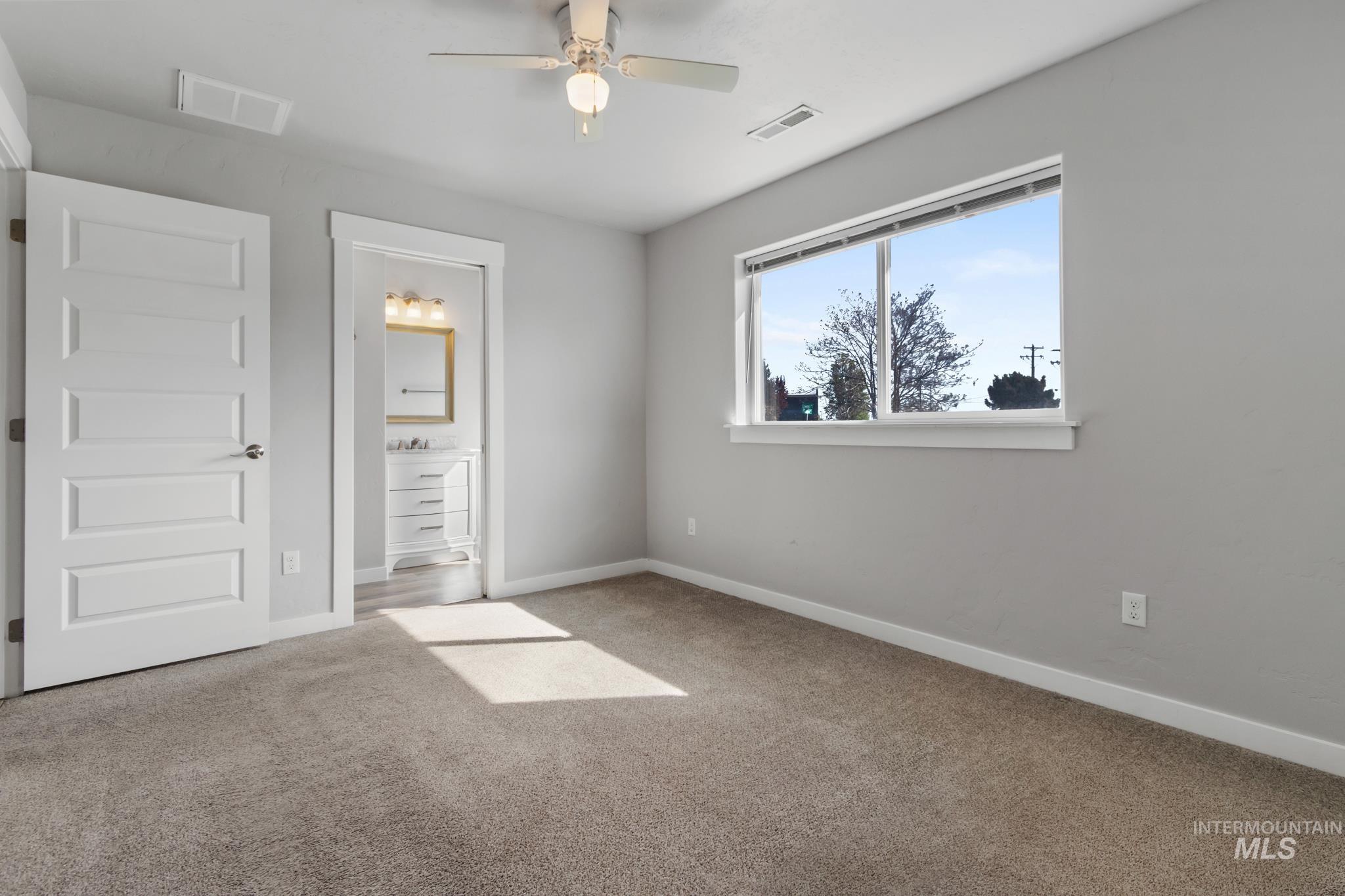 4822 Charme Street Caldwell, ID 83607 - Photo 18 of 22 Unfurnished bedroom with connected bathroom and light colored carpet