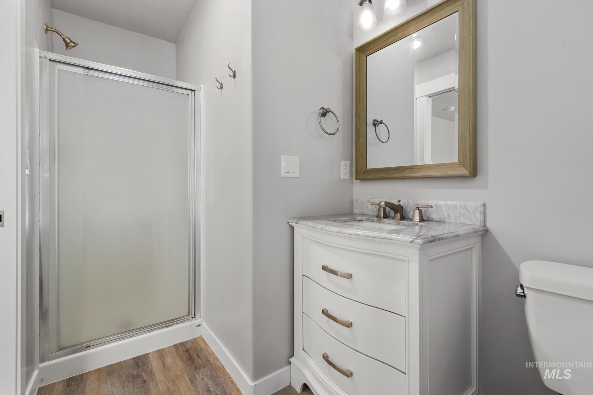 4822 Charme Street Caldwell, ID 83607 - Photo 19 of 22 Full bathroom with a stall shower, vanity, and light wood finished floors