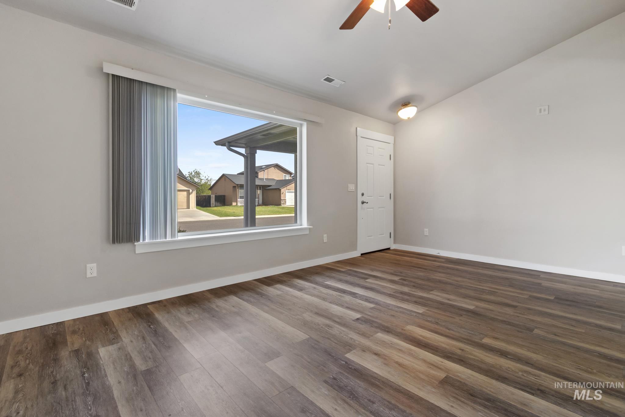4822 Charme Street Caldwell, ID 83607 - Photo 4 of 22 Empty room featuring ceiling fan, dark wood-style flooring, and lofted ceiling