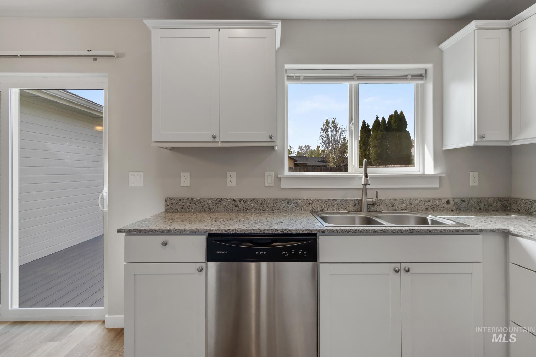 4822 Charme Street Caldwell, ID 83607 - Photo 8 of 22 Kitchen with dishwasher, white cabinetry, light stone counters, and light wood-style floors