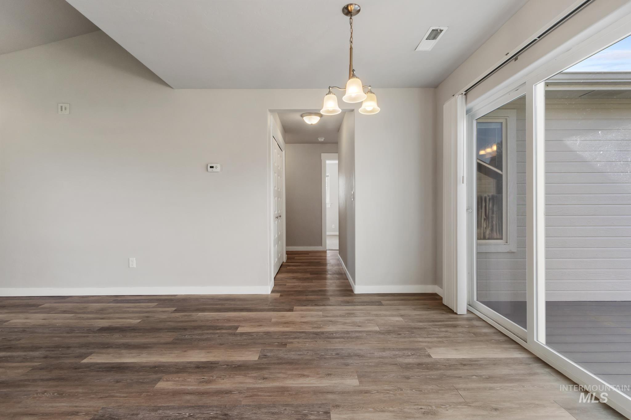 4822 Charme Street Caldwell, ID 83607 - Photo 10 of 22 Unfurnished dining area featuring wood finished floors and hanging lights