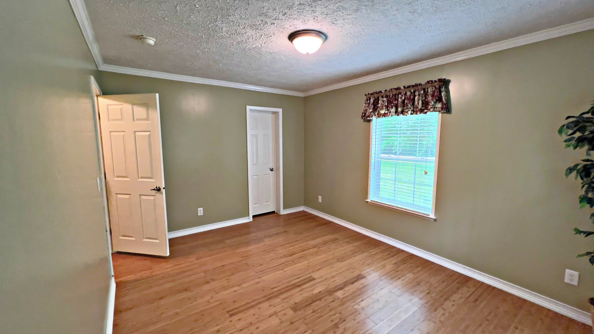 4027 Forrest Hill Road Bolivar, TN 38008 - Photo 20 of 32 an empty room with wooden floor and windows