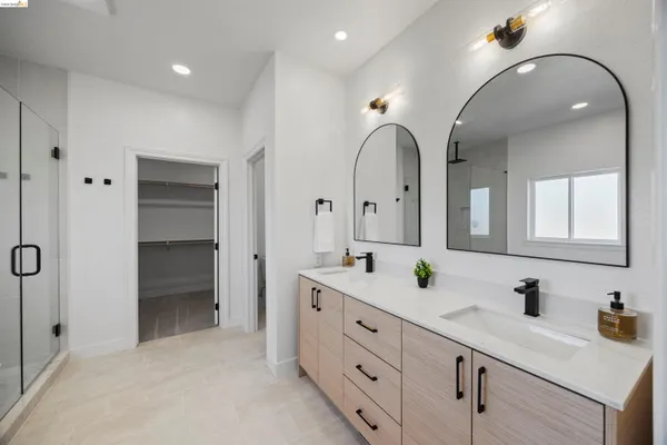 a bedroom with a bed chandelier and a window
