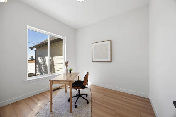 a view of a workspace with furniture and wooden floor