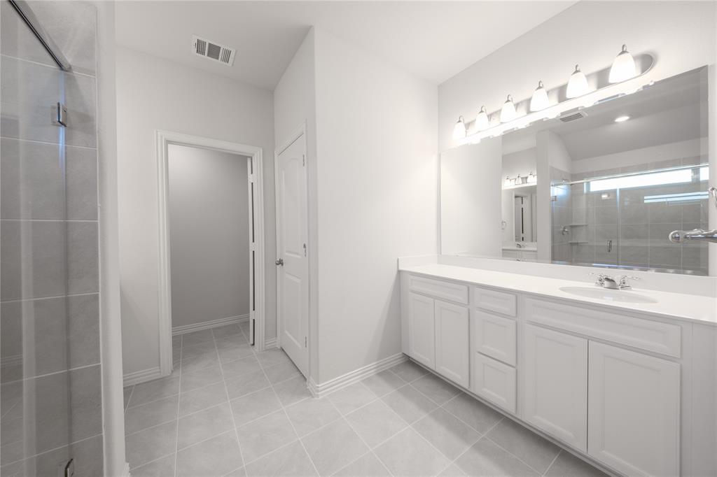 2613 Spade Street Anna, TX 75409 - Photo 14 of 38 a bathroom with a double vanity sink and a mirror
