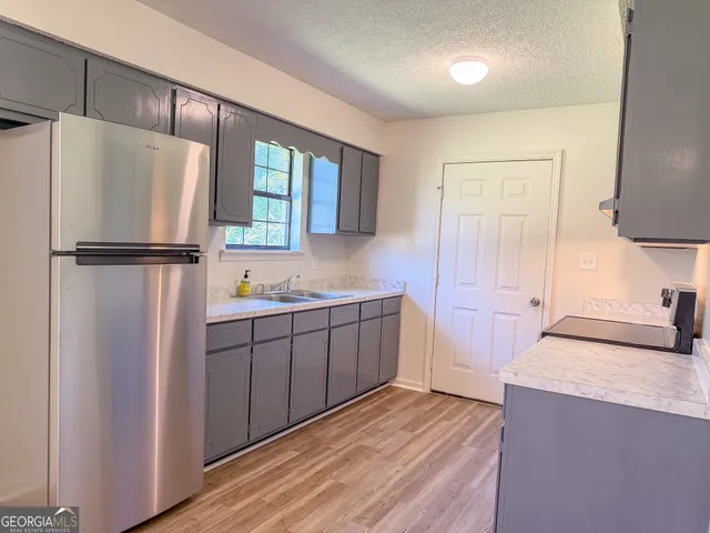 a kitchen with granite countertop a refrigerator and a sink