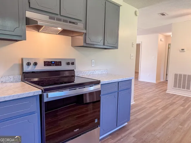 a kitchen with wooden cabinets and a stove top oven