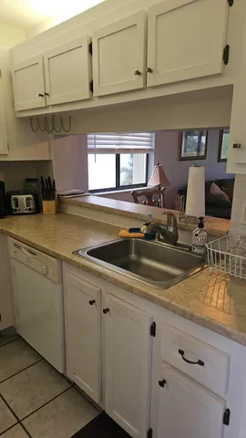 a kitchen with stainless steel appliances granite countertop a refrigerator a stove a sink and white cabinets