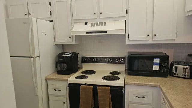 a view of a kitchen with a sink and a refrigerator