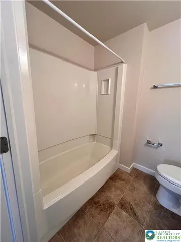 a bathroom with a bathtub and a toilet