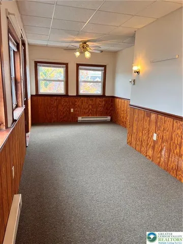 an empty room with windows and cabinet