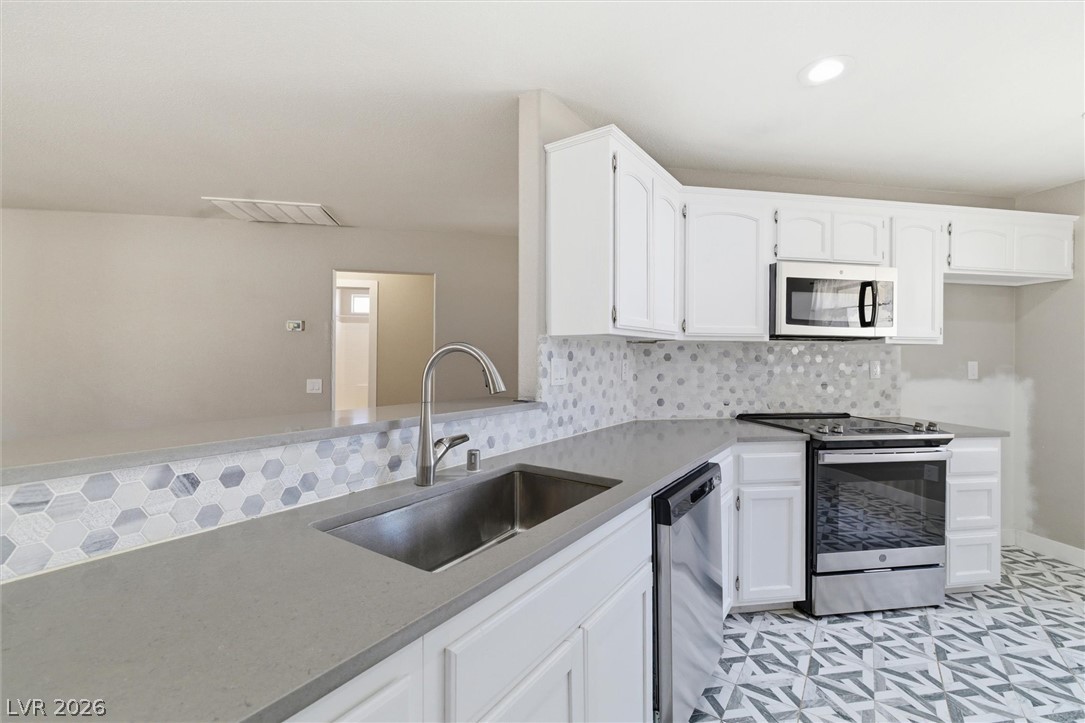 2780 West Simkins Road Pahrump, NV 89060 - Photo 15 of 40 Modern kitchen with sleek countertops and stylish hexagonal tile backsplash.