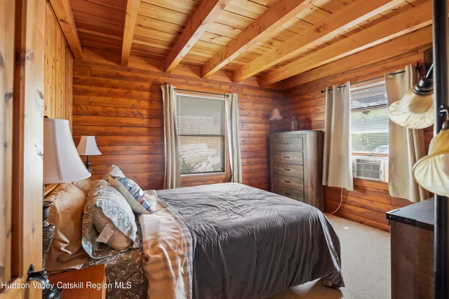 a bedroom with a bed next to a window