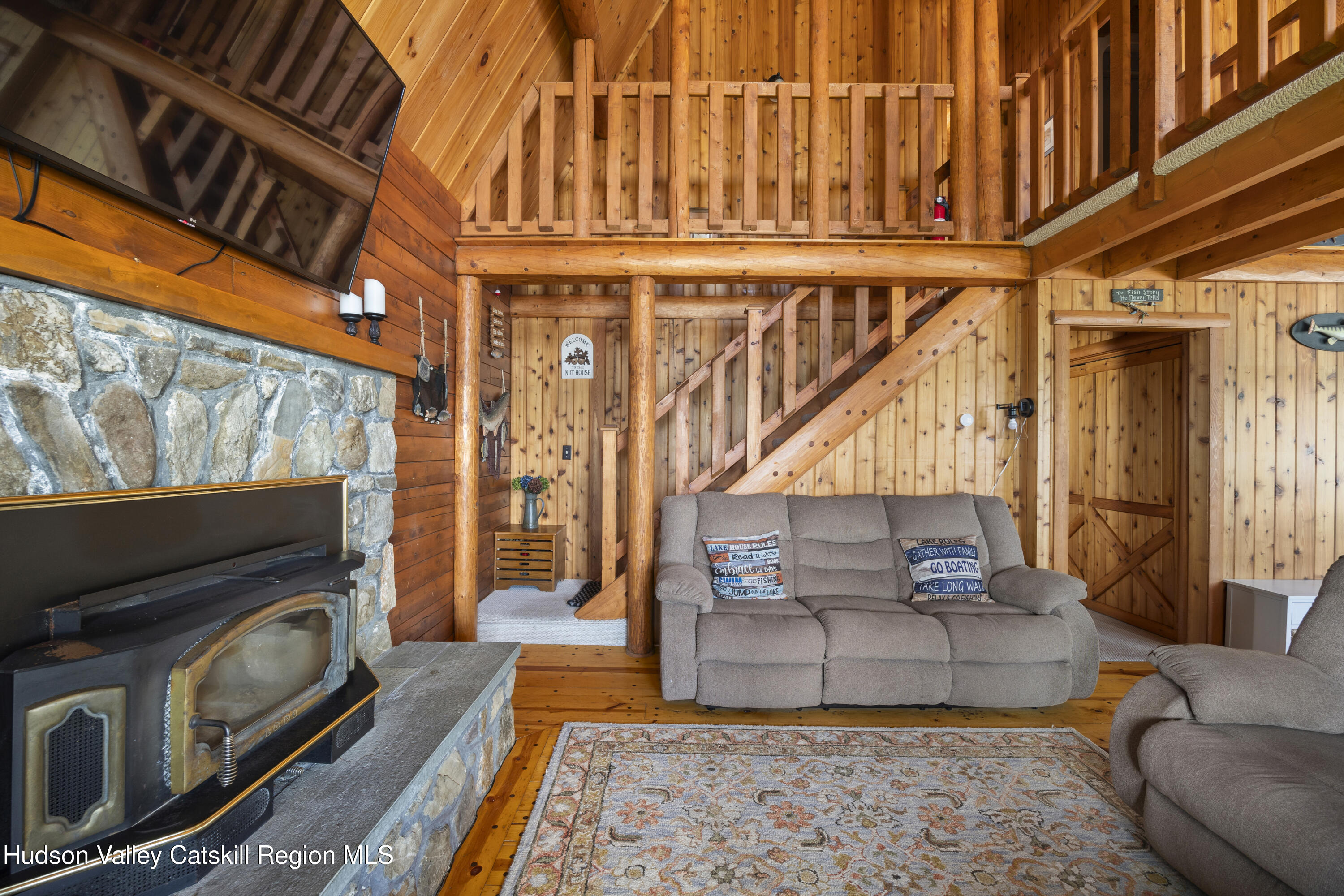 407 Lakeview Road Craryville, NY 12521 - Photo 13 of 24 a living room with furniture a fireplace and a flat screen tv