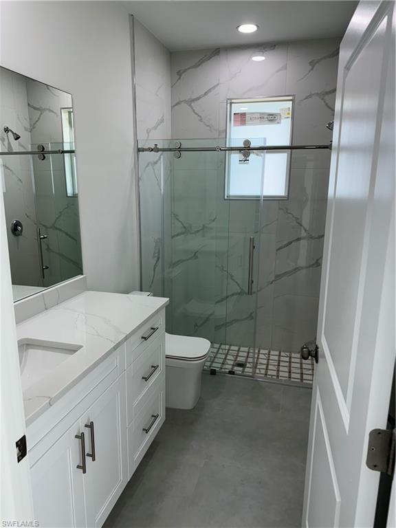 829 Albert Avenue Lehigh Acres, FL 33971 - Photo 20 of 27 a bathroom with a granite countertop sink a toilet and shower