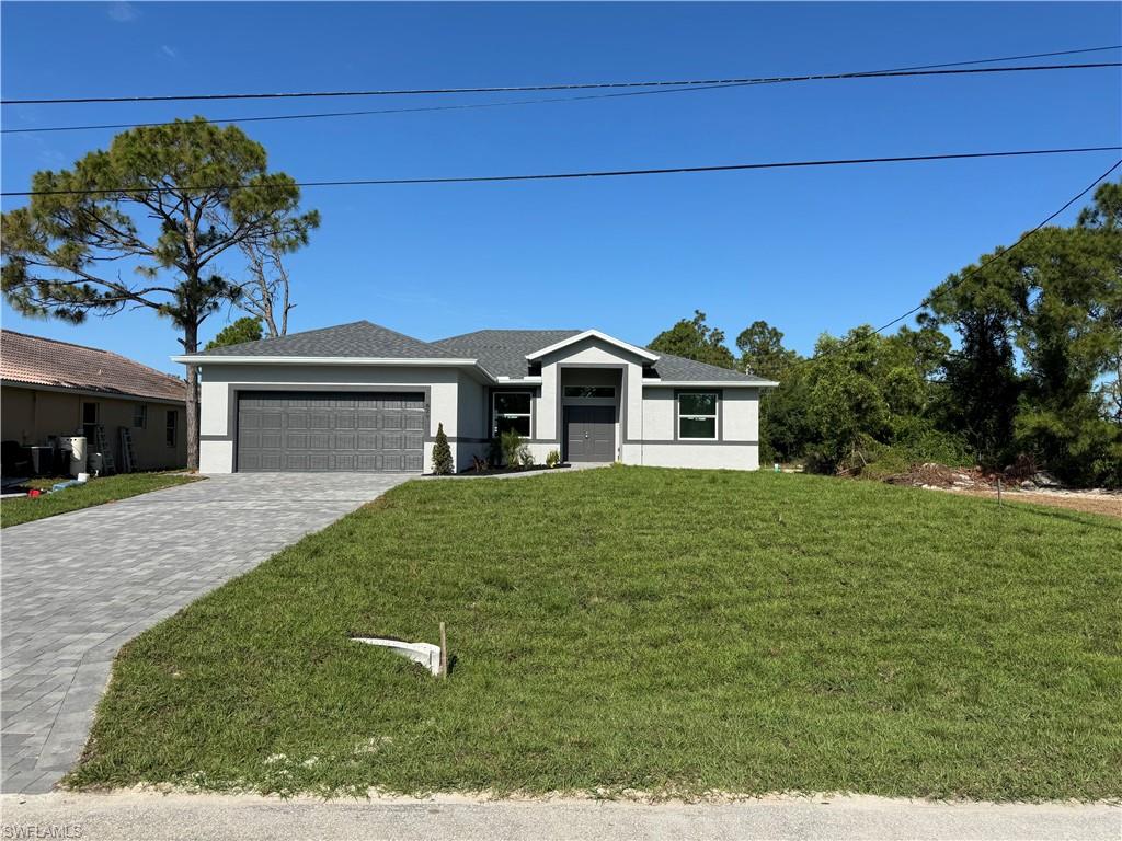 829 Albert Avenue Lehigh Acres, FL 33971 - Photo 2 of 27 a front view of a house with a yard