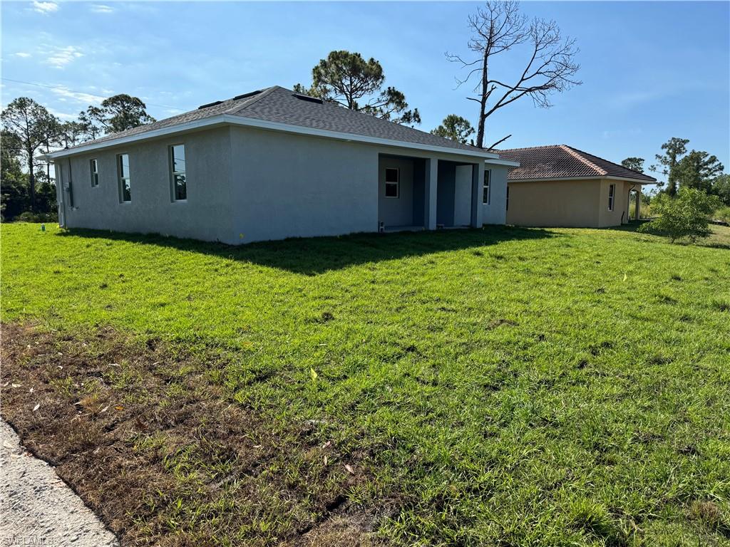 829 Albert Avenue Lehigh Acres, FL 33971 - Photo 4 of 27 a front view of a house with garden