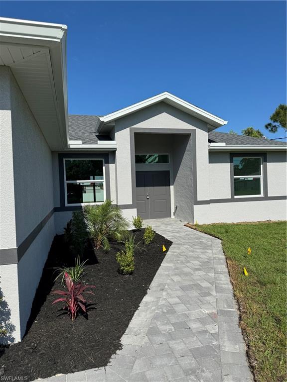 829 Albert Avenue Lehigh Acres, FL 33971 - Photo 7 of 27 a front view of a house with garden