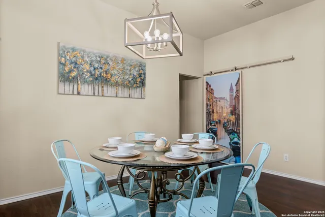a view of a dining room with furniture a chandelier and wooden floor