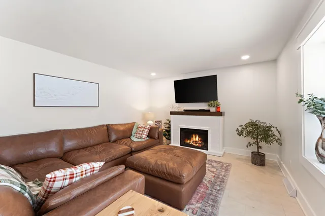 a living room with furniture large windows and wooden floor