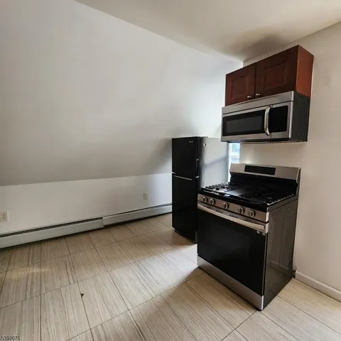 a kitchen with stainless steel appliances a stove a microwave and a hard wood floors