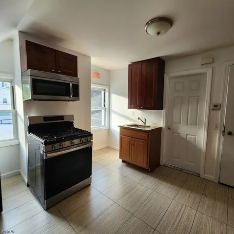 a kitchen with stainless steel appliances kitchen island granite countertop a stove a sink and a microwave