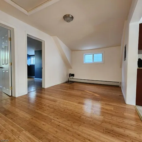 a view of a room with wooden floor and a window