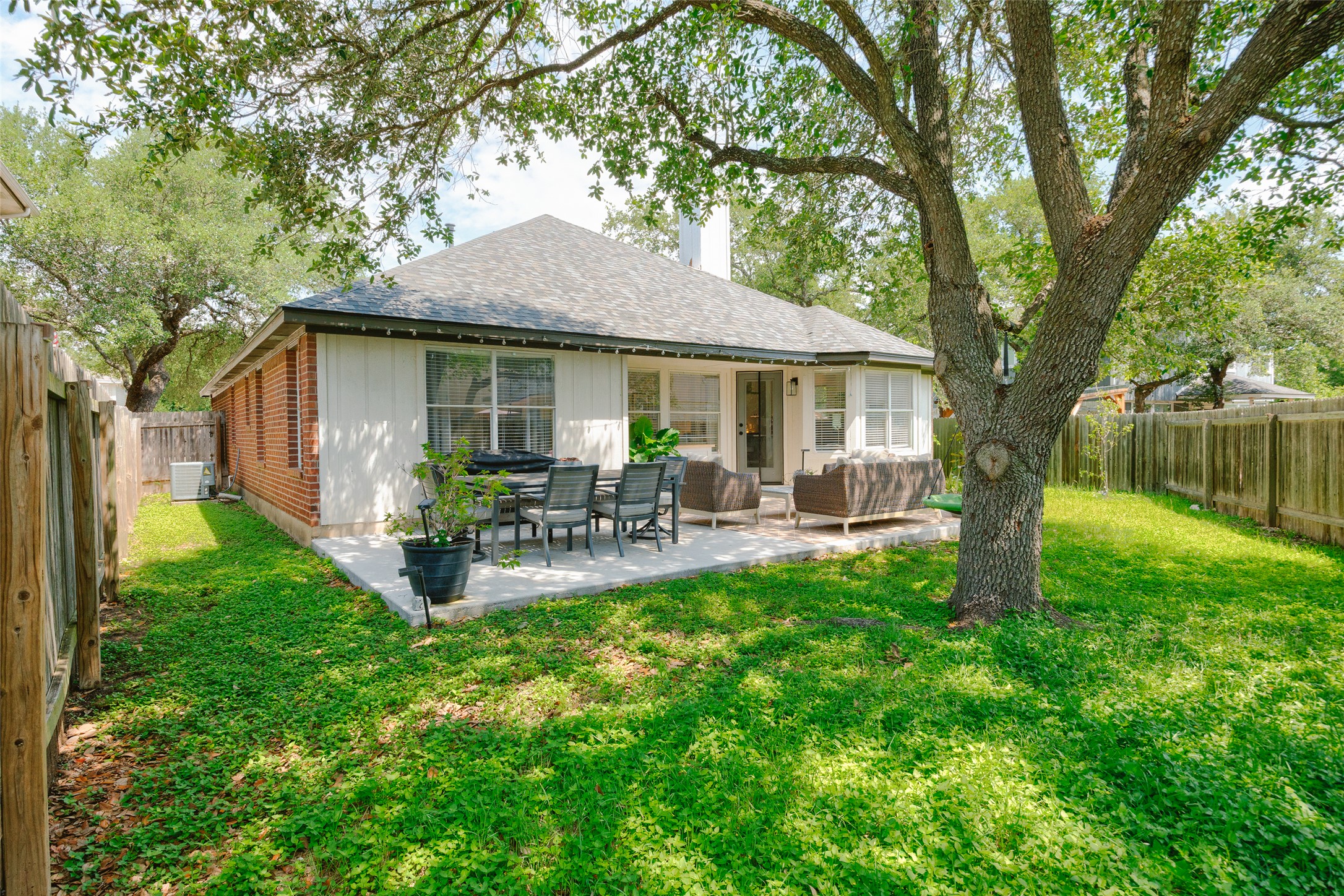 2202 Old Mill Road Cedar Park, TX 78613 - Photo 21 of 23 A spacious backyard with mature trees, a fence, and a generous patio offers an ideal setting for outdoor gatherings.