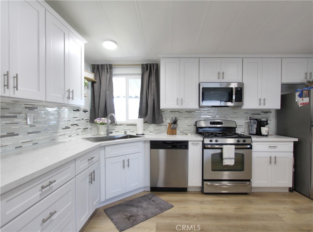 692 North Adele Street, Unit 101 Orange, CA 92867 - Photo 9 of 20 a kitchen with stainless steel appliances granite countertop a sink a stove a refrigerator and cabinets