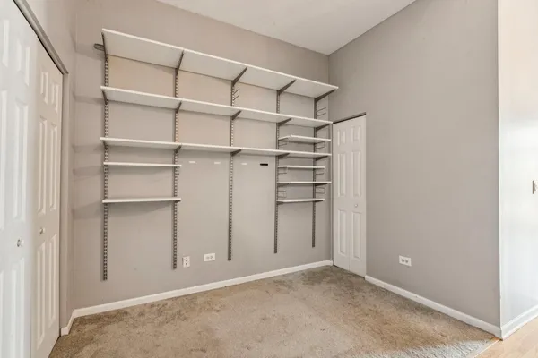 a view of walk in closet with empty racks