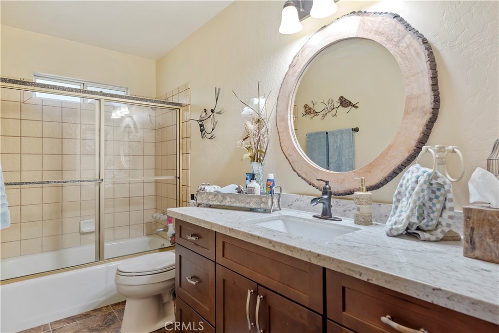 615 Wellesley Lake Arrowhead, CA 92352 - Photo 20 of 45 a bathroom with a granite countertop toilet a sink and a mirror