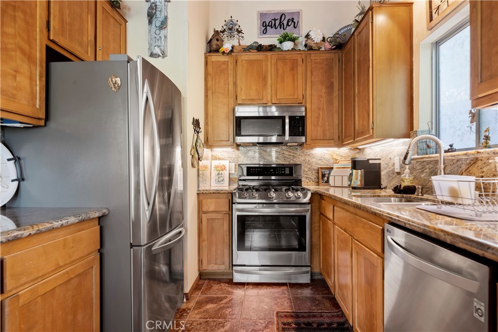 615 Wellesley Lake Arrowhead, CA 92352 - Photo 9 of 45 a kitchen with stainless steel appliances a refrigerator sink and microwave