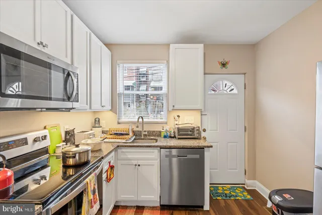 a kitchen with stainless steel appliances granite countertop a sink stove and cabinets