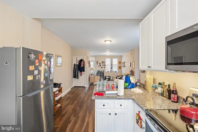 a room with furniture a flat screen tv and refrigerator
