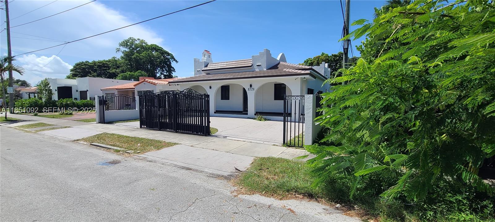 1721 Southwest 24th Terrace Miami, FL 33145 - Photo 1 of 80 a view of a white house with large windows and a small yard