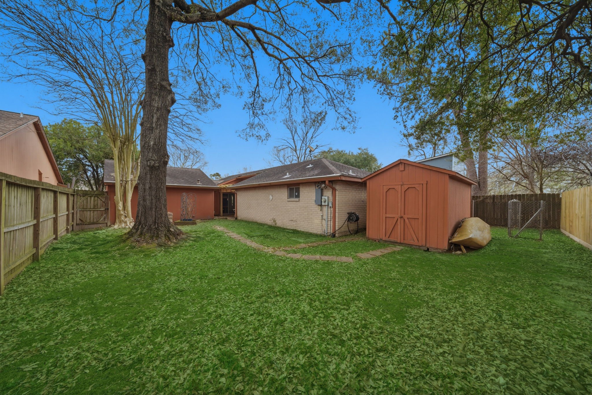 5822 Skewen Street Humble, TX 77346 - Photo 26 of 29 Large backyard with mature trees and a large shed for additional storage.