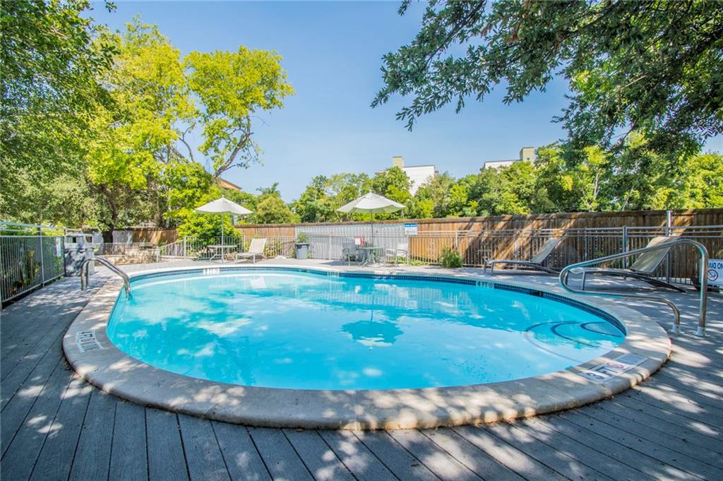 3204 Manchaca Road, Unit 302 Austin, TX 78704 - Photo 5 of 20 Mature trees frame a sun-drenched swimming pool bordered by a spacious wooden deck.